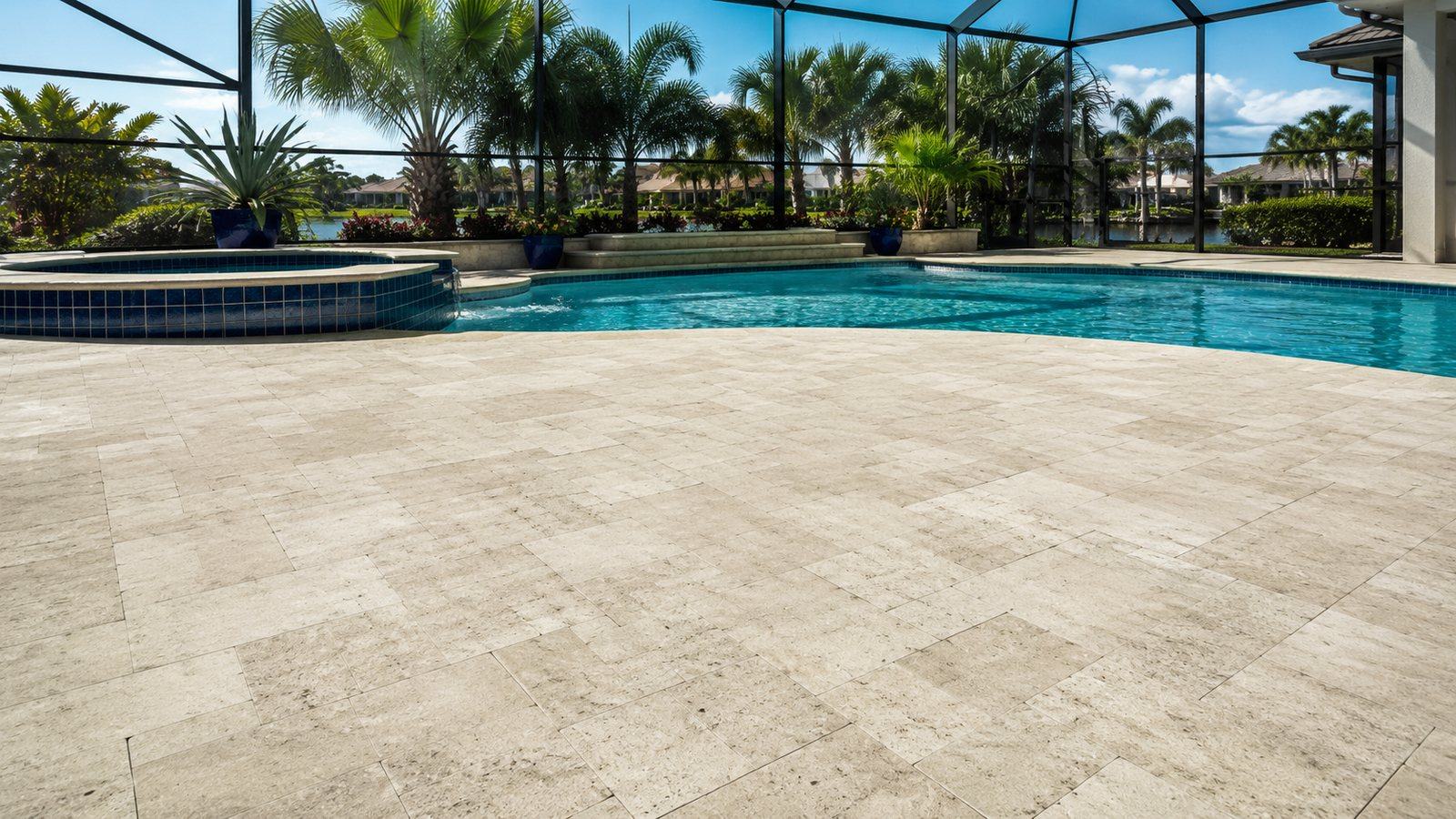 A freshly resurfaced travertine pool deck in a Cape Coral backyard